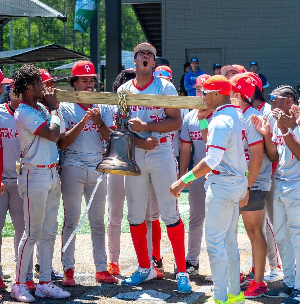 Georgia Premier players celebrate with the championship bell at home plate